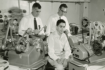 image of workers looking at film reels