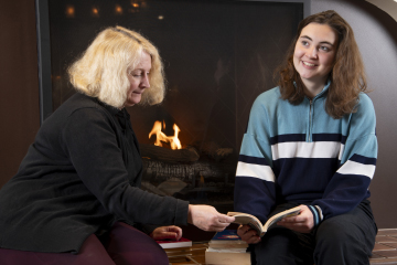 a librarian looking at a book with a student