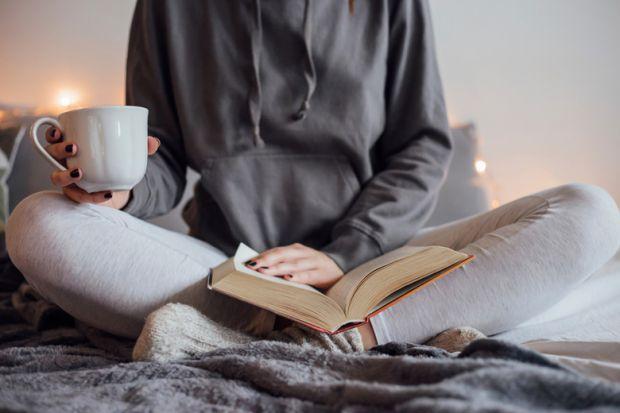 girl reading and drinking coffee in dorm