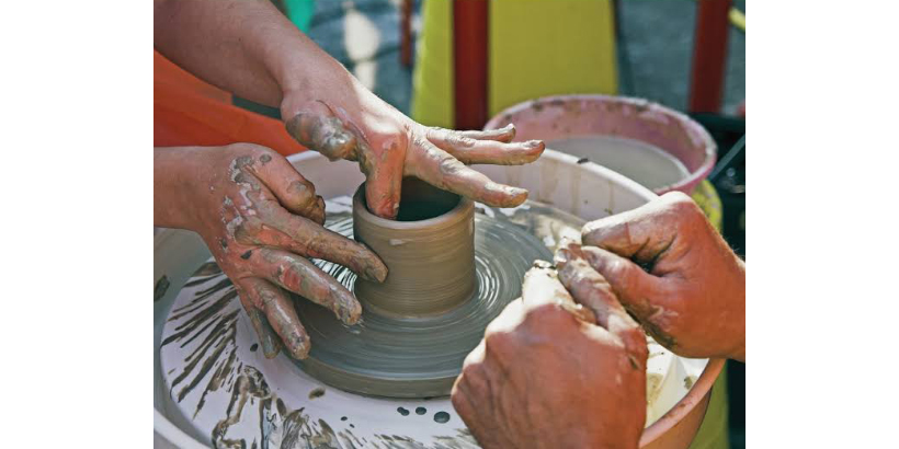 artists hands at a potter's wheel