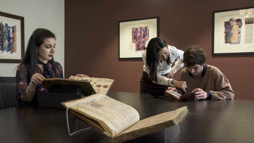 Jennifer Smith with students looking at medieval manuscripts