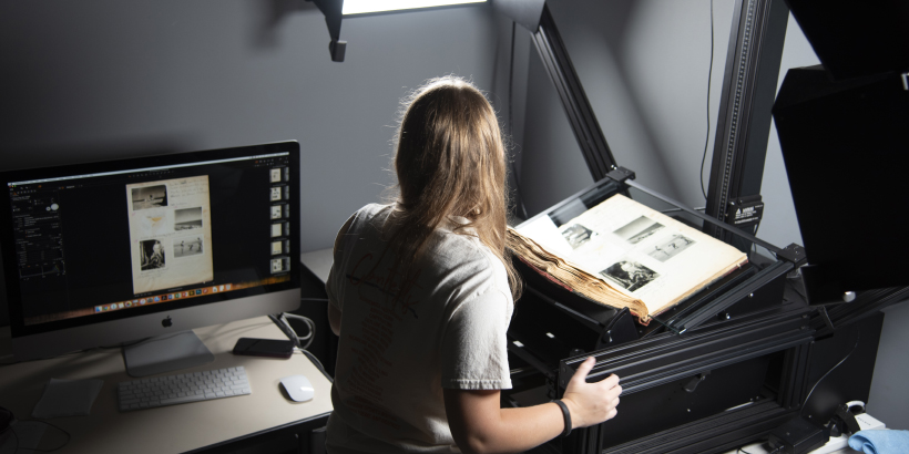 library worker scanning photographs and looking at computer screen