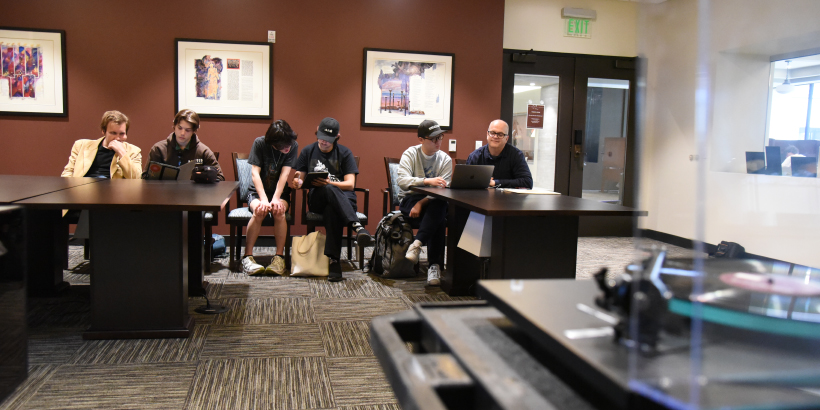 students and Lincoln Hanks listening to music in the Special Collections Reading Room